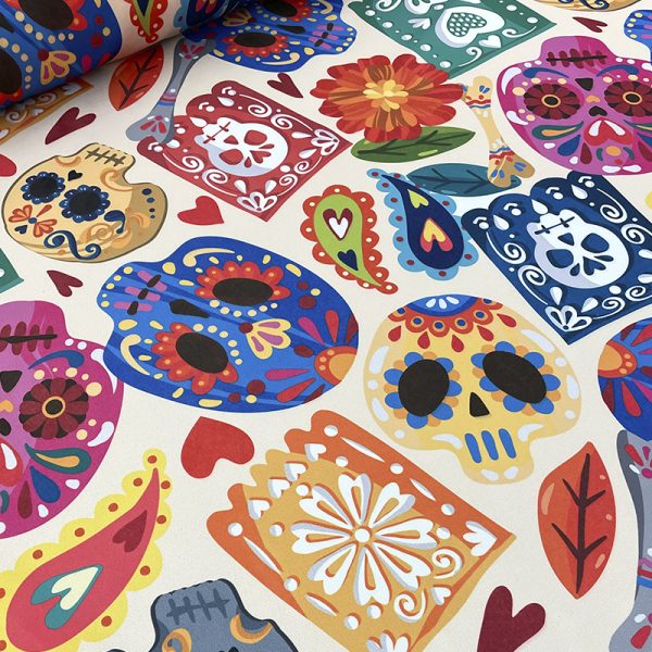 Tela con calaveras coloridas, flores y papel picado para decorar Día de Muertos