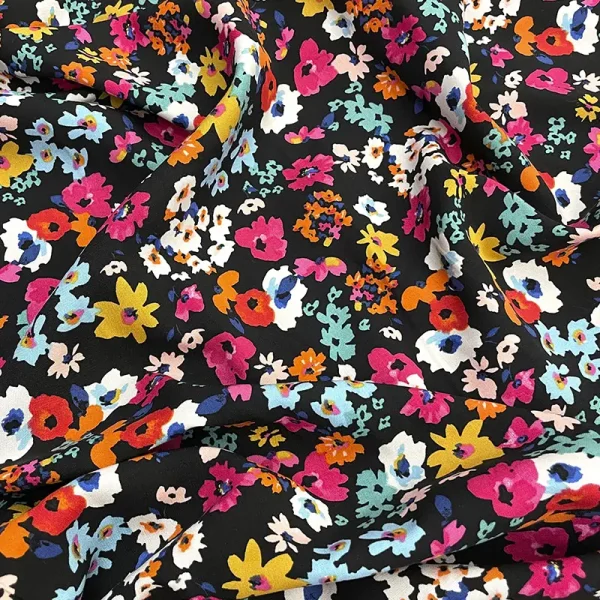 Tela poplin rayón floral en fondo negro con flores fucsias, turquesa, naranjas y blancas