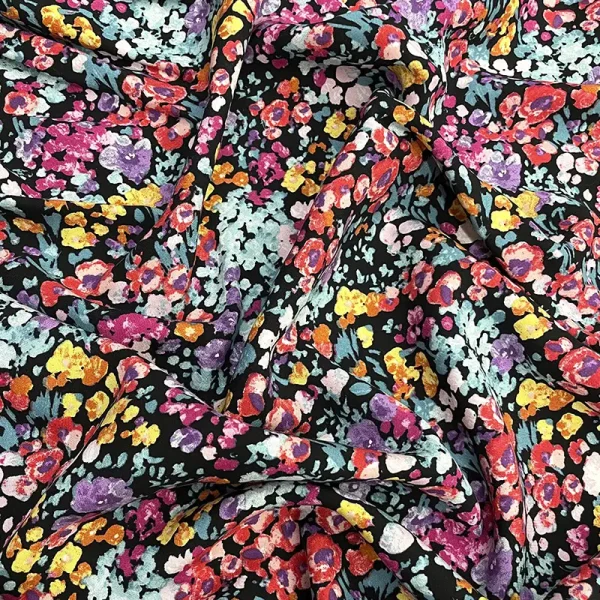 Tela poplin rayón con flores vibrantes en tonos rojo, lila, rosa y amarillo sobre fondo negro