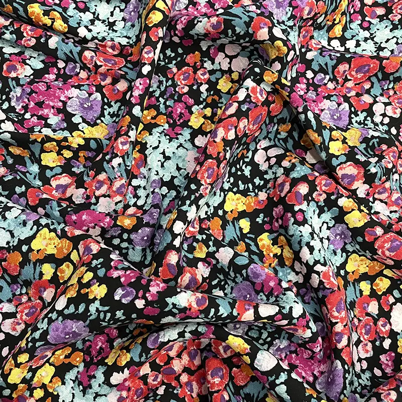 Tela poplin rayón con flores vibrantes en tonos rojo, lila, rosa y amarillo sobre fondo negro