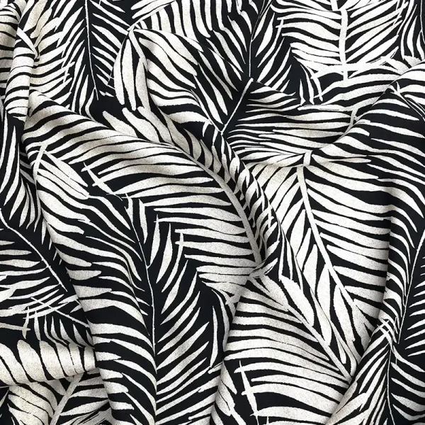 Tela poplin rayón con hojas blancas sobre fondo negro, diseño tropical monocromático