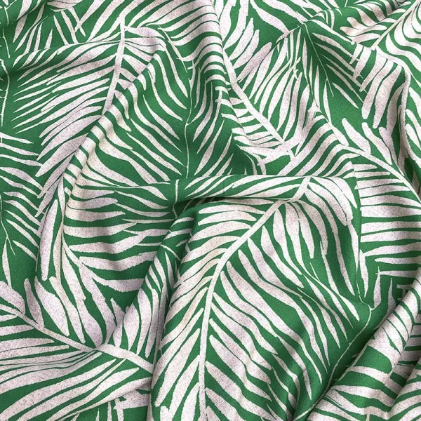 Tela poplin rayón con hojas blancas sobre fondo verde, diseño tropical moderno