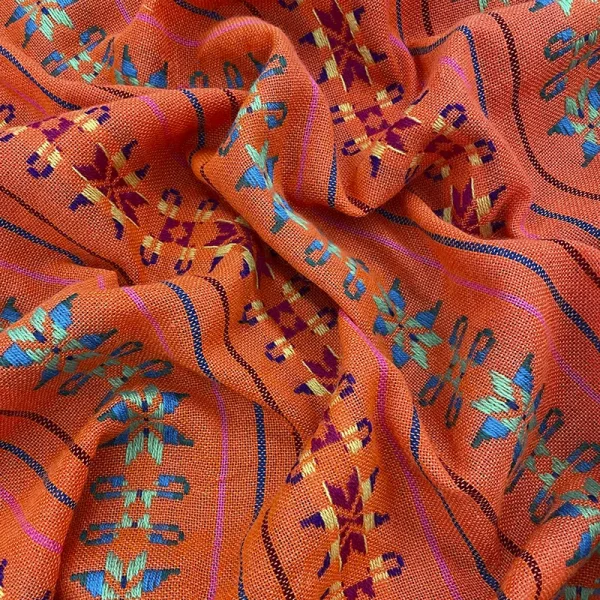 Tela cambaya color naranja con bordado de flores multicolor