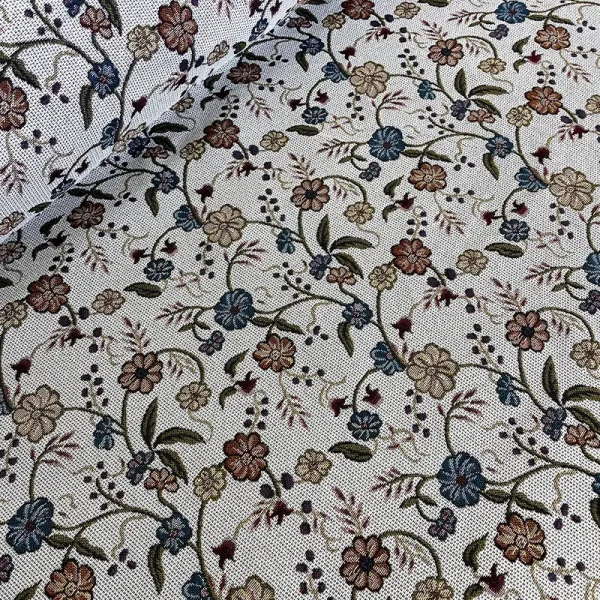Tela gobelino con flores ramificadas en tonos azul, beige y terracota sobre fondo blanco.