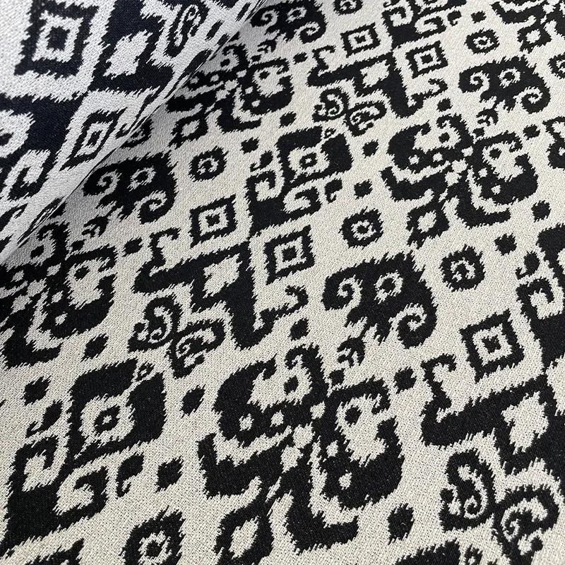 Tela con patrón de manchas negras estilo Rorschach sobre fondo crudo.
