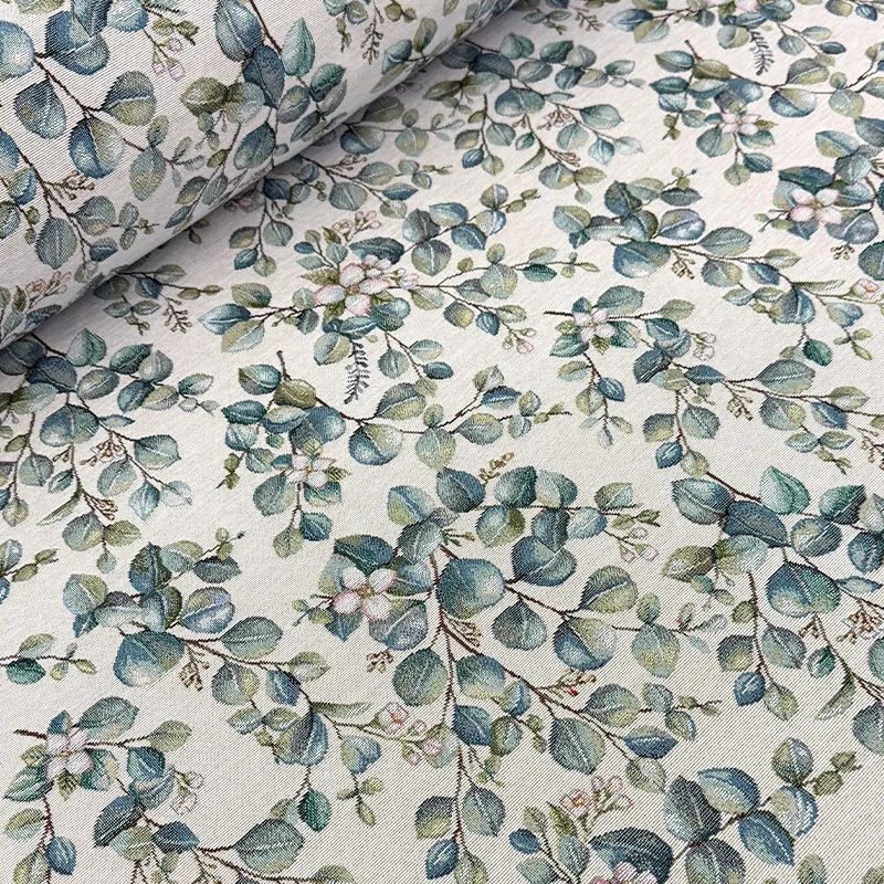Detalle de tela gobelino modelo Eden con estampado denso de hojas verdes de distintas formas y tamaños sobre un fondo beige