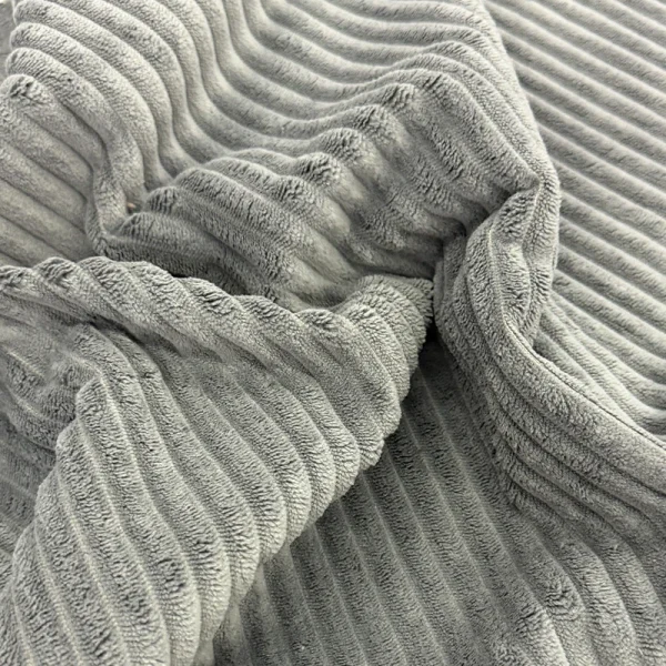 Muestra de tela Niagara en color gris oscuro con relieve de patrón lineal, textura suave y gruesa para tapicería de muebles.