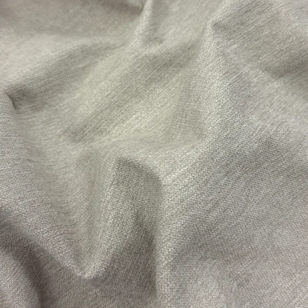 Detalle de tela de poliéster gruesa y resistente en color ivory (marfil) modelo Hawai, ideal para tapicería de muebles de lujo y decoración de interiores.