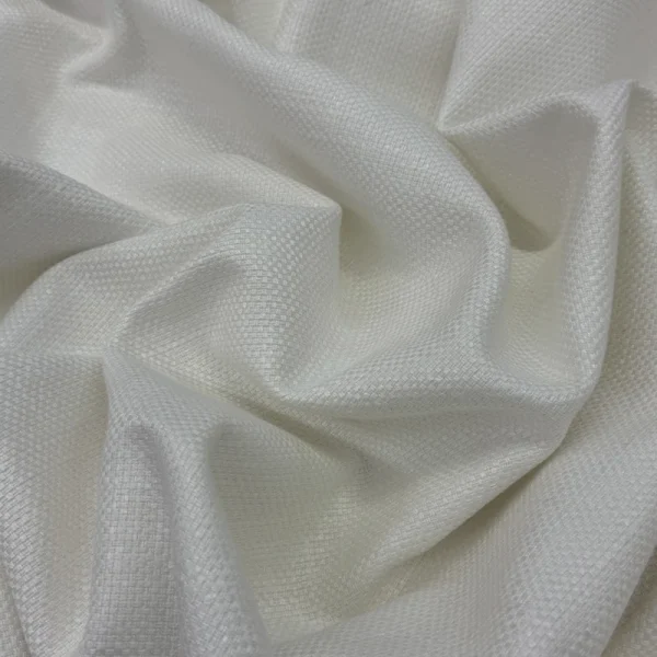 Primer plano de los pliegues de la Tela Siena en color blanco, mostrando su textura de tejido plano resistente y su acabado luminoso.