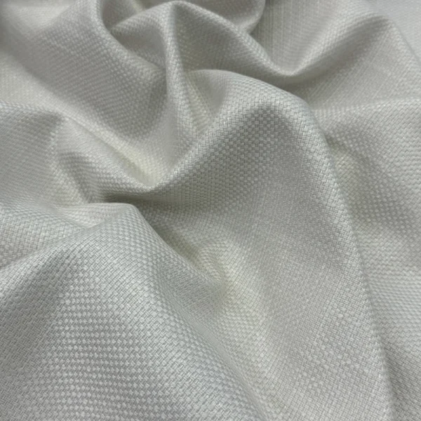 Primer plano de los pliegues de la Tela Siena en color marfil, mostrando su trama de tejido plano resistente y su acabado textil elegante y luminoso.