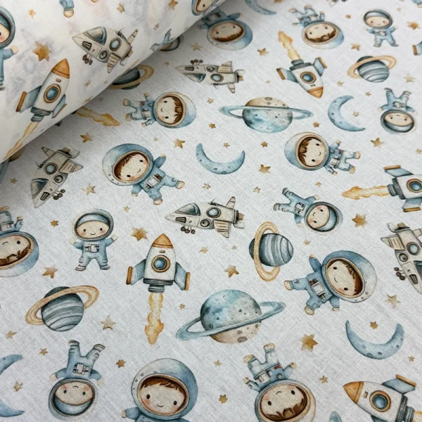 Primer plano de la Tela Petite Astronautas en el Espacio, mostrando pequeños cohetes, planetas y astronautas sobre fondo blanco.