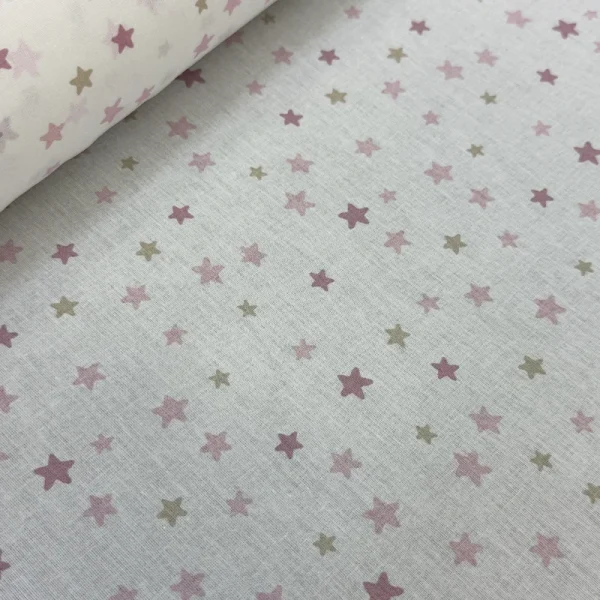 Tela Petite Constelación Rosa y Beige con estampado digital de estrellas diminutas en fondo blanco para costura y confección de ropa infantil.