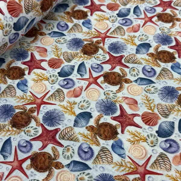Tela Petite Tortugas y Conchas Marinas con estampado digital de tortuguitas marinas, estrellas y conchas para confección de ropa de verano.