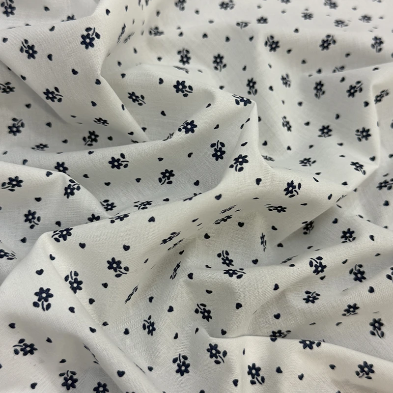 Tela Annie con diseño de estampado floral con pequeñas flores y corazones azul marino sobre fondo blanco de la imagen image_6a8097.jpg.