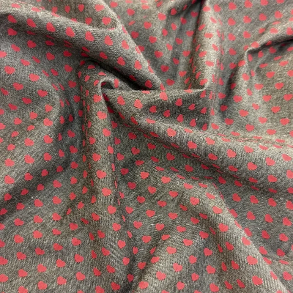 Polo Chambray Corazones Carmesí con pequeños corazones rojos estampados sobre fondo gris para confección de prendas.