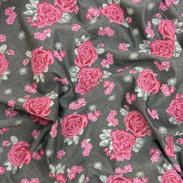 Polo Chambray Rosas Carmesí con flores rosas sobre fondo gris.