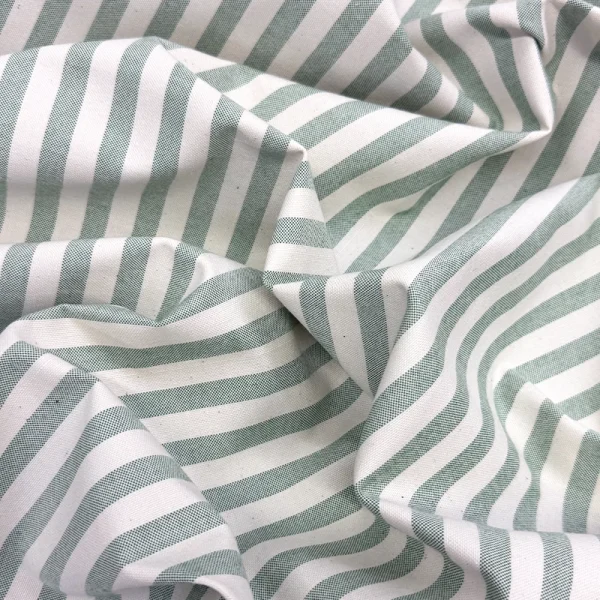Tela decorativa Raya Bosque con diseño de franjas color verde bandera sobre fondo crudo, ideal para cortinas, mantelería y decoración del hogar.