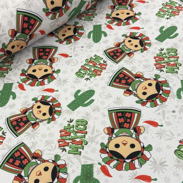 Tela mantelera Muñequita Patria con estampado de muñequitas mexicanas, cactus, chiles y la frase Viva México sobre fondo blanco.