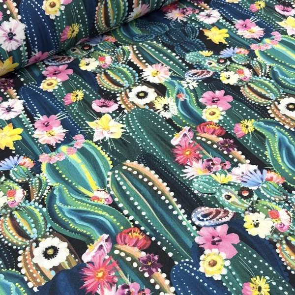 Tela mantelera Noches del Nopal con estampado de cactus verdes y flores multicolor sobre fondo negro en tela tafetán de poliéster.