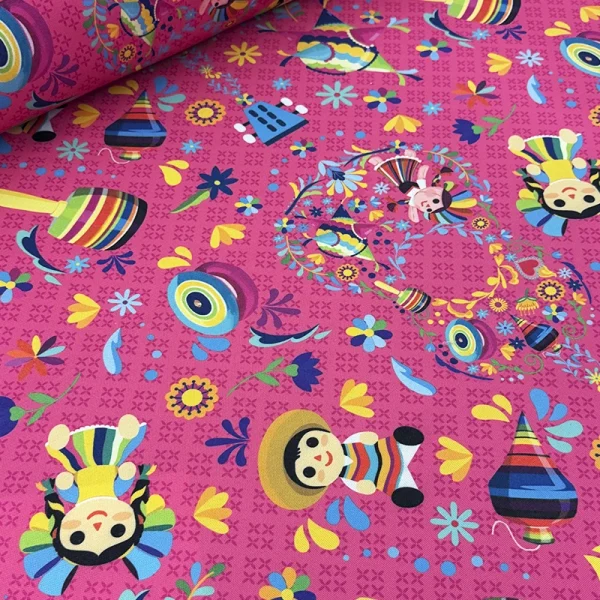 Tela mantelera Recuerdos de Feria con estampado de muñecas mexicanas, trompos, baleros, piñatas y flores sobre fondo rosa.