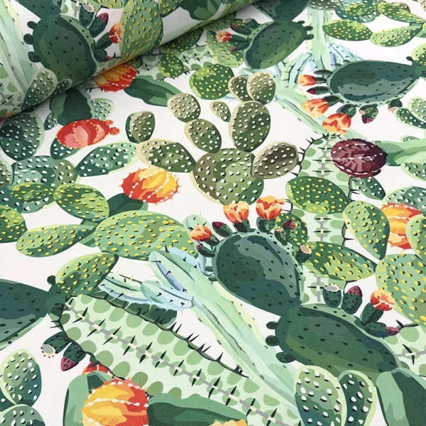 Tela mantelera Rincón del Nopal con estampado de nopales, cactus y tunas en tonos verdes sobre fondo blanco, ideal para mantelería y decoración.
