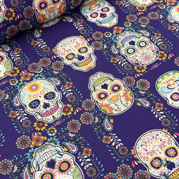 Genova 170 Calaveras Mexicanas Morado con calaveras decoradas y flores multicolor sobre fondo morado.